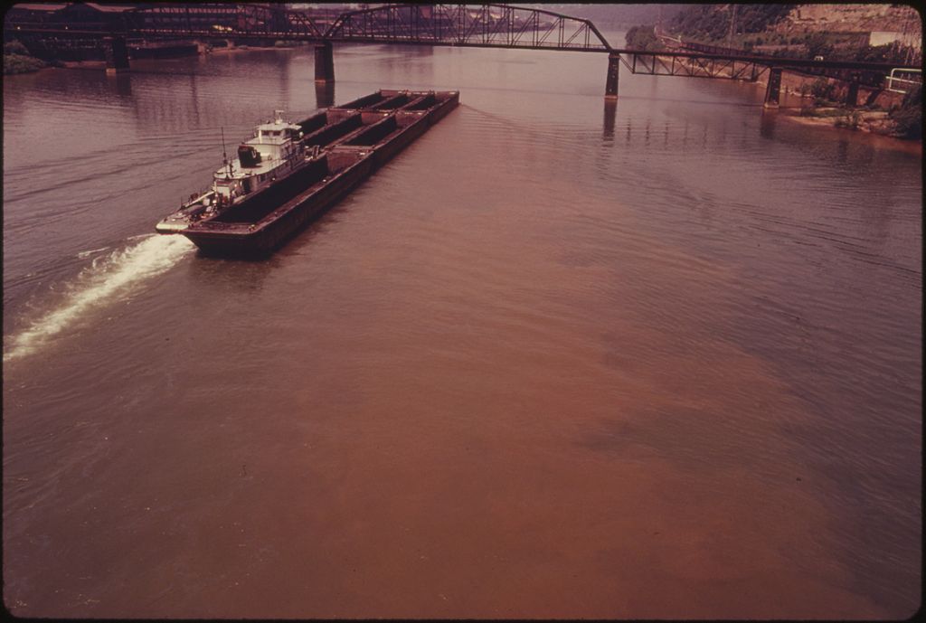 1024px-BARGE_ON_THE_MONONGAHELA_RIVER_SHOWS_EFFECTS_OF_POLLUTION_CAUSED_BY_AN_OIL_SPILL_AT_THE_DUQUESNE_WORKS_OF_THE_UNITED____-_NARA_-_557235.jpg
